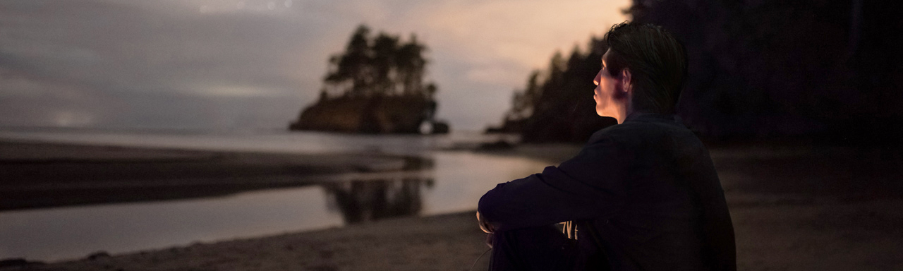 Person looking across water at dusk or dawn